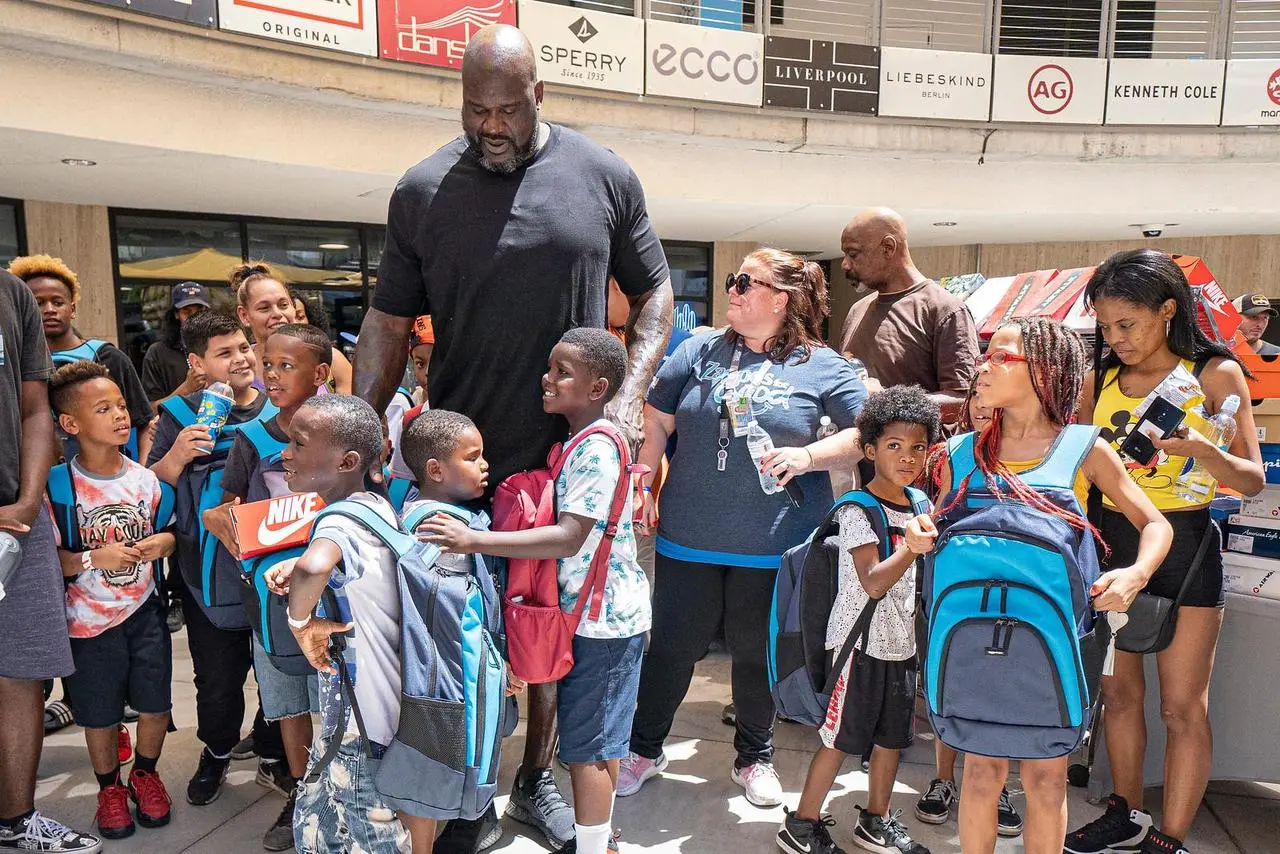 Shaquille O'Neal community event shoe giveaway with children for outdoor marketing in Las Vegas
